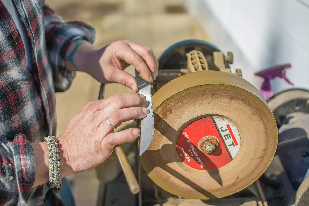 Knife sharpening on a whetstone with a leather strop beside the stone